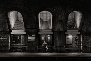 Woman sat on bench in front of London's Baker St Station