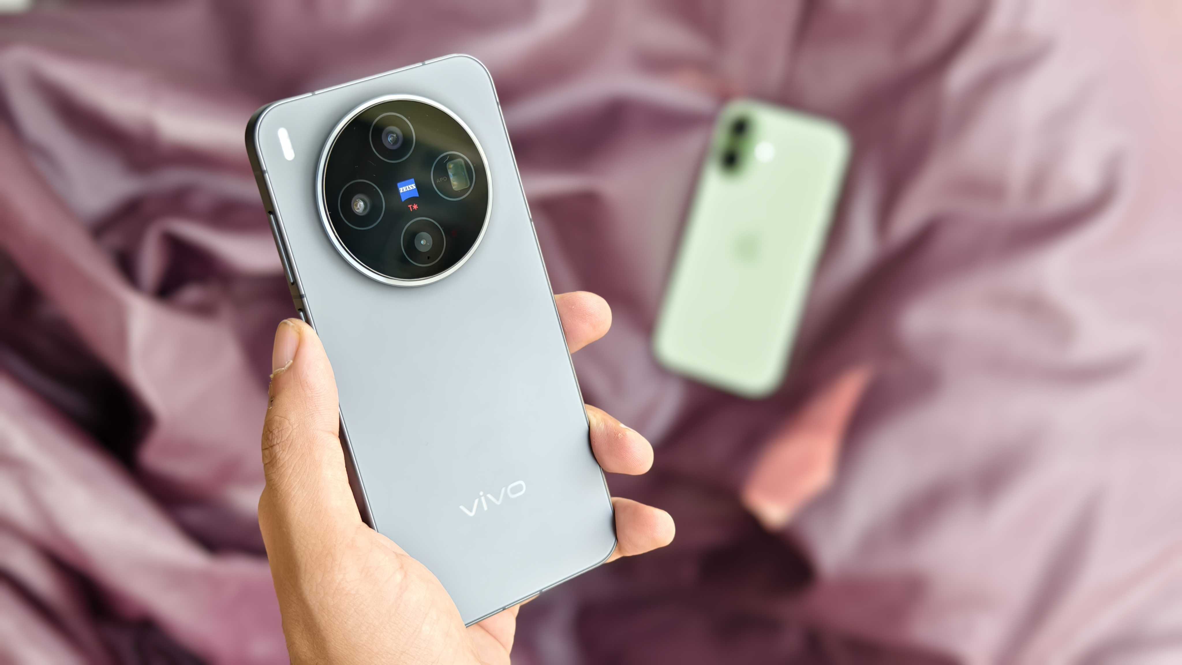 Prakhar Khanna holding the Vivo X300 with the Apple iPhone 17 in the background.