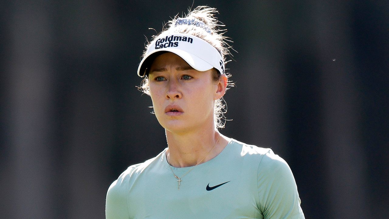 Nelly Korda wearing a white visor and green Nike top during an LPGA event