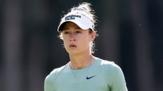 Nelly Korda wearing a white visor and green Nike top during an LPGA event