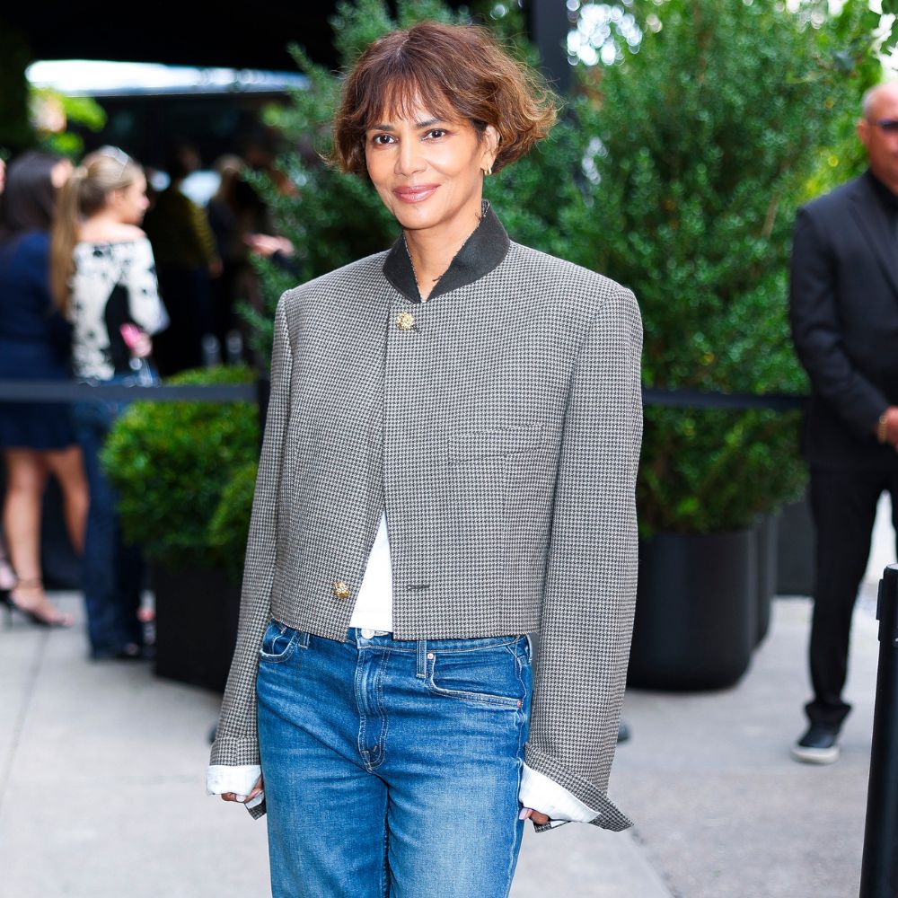 Halle Berry wears low-rise puddle jeans with heels and a single-breasted jacket at a Chanel event in New York.