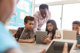 Teacher and two students with a tablet.