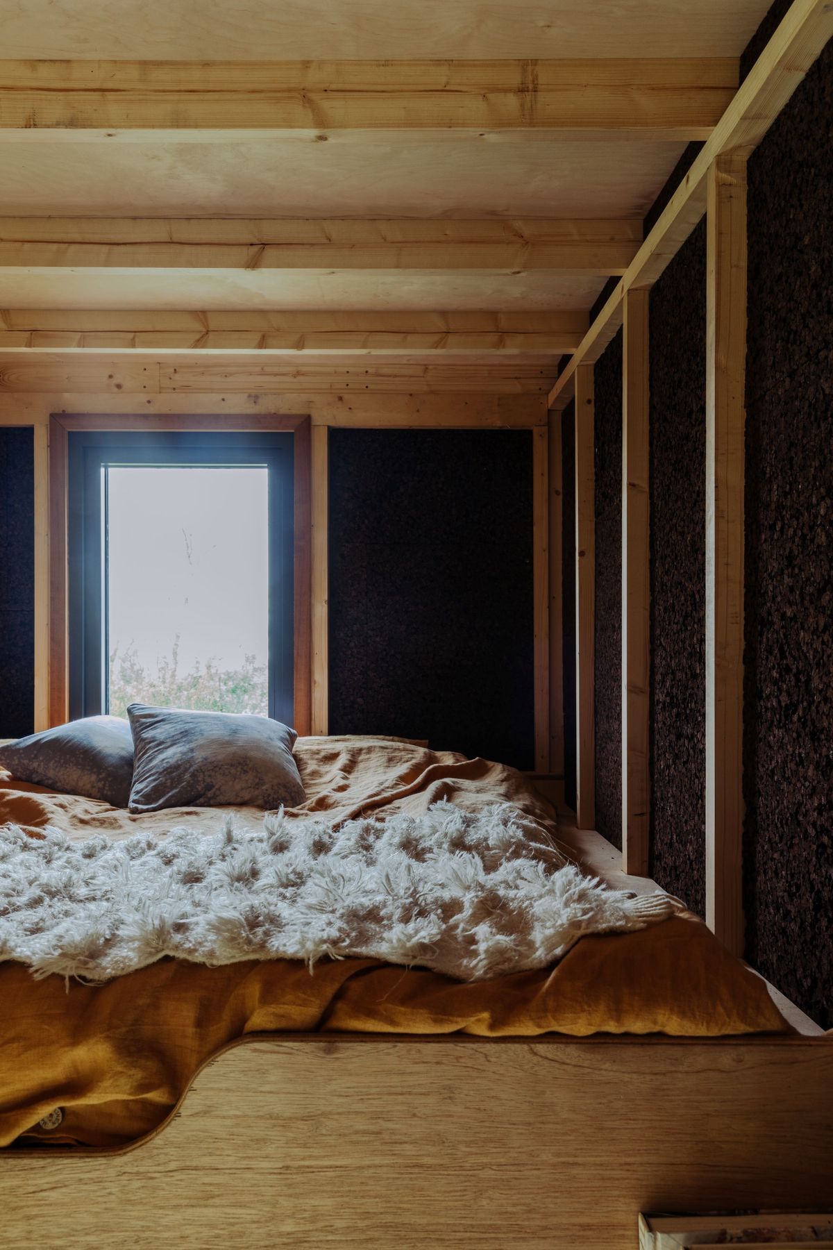 The bedroom at the top of the tiny eco homes with cork walls