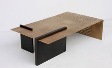 coffee table made from gold-bronze medal perforated brass, with a gunmetal steel base