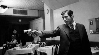 Al Pacino holds a gun in The Godfather
