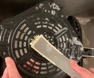 Cleaning the Ninja Air Fryer Pro 4-in-1 with a silicone scrubber