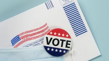 Envelope with ballot inside, election pin and face mask