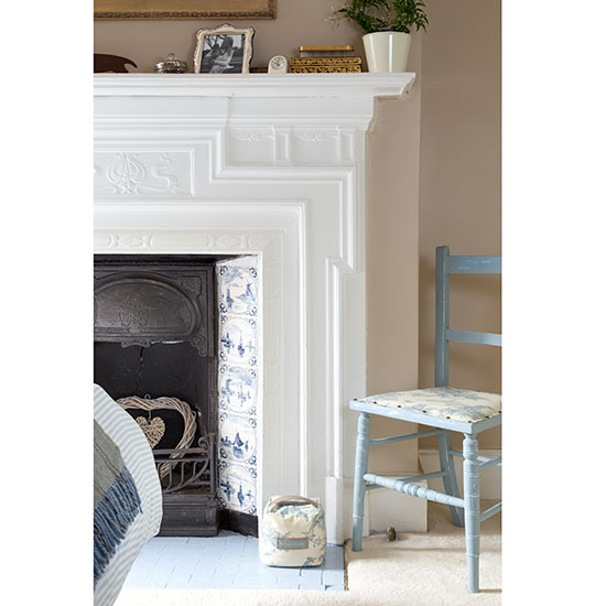 white fire place pink wall and blue chair