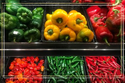 a supermarket shelf showing different varieties of peppers - red, yellow and green bell peppers