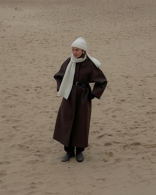 @brittanybathgate wearing a brown coat, white scarf and beanie