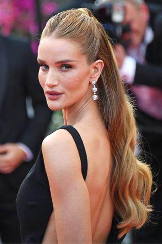 Rosie Huntington-Whiteley with her hair half-up half-down, looking over her shoulder