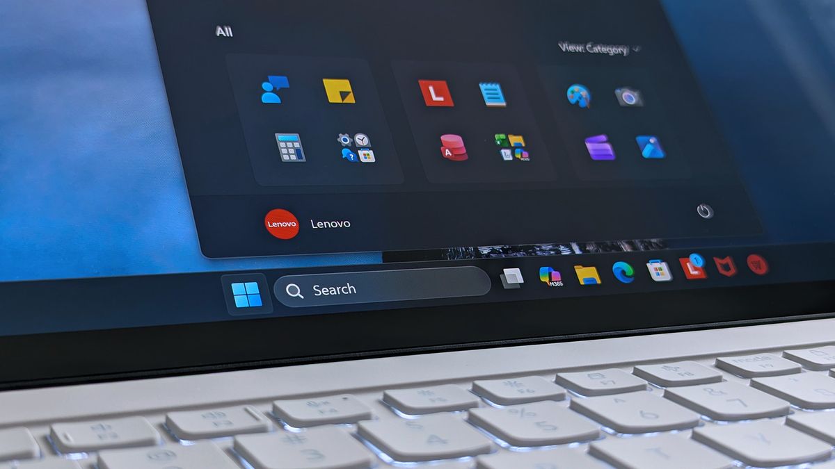 A Lenovo Yoga Slim 7i Ultra (Gen 11) Aura Edition laptop screen shows a home screen with open taskbar featuring app icons.
