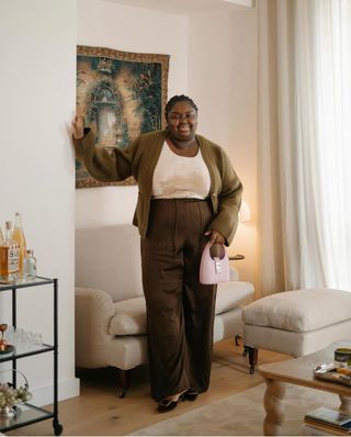 STILVOLLE CARDIGAN-OUTFITS FÜR DEN HERBST 2024: Abi trägt eine braune Hose, ein Trägershirt und eine khakifarbene Strickjacke