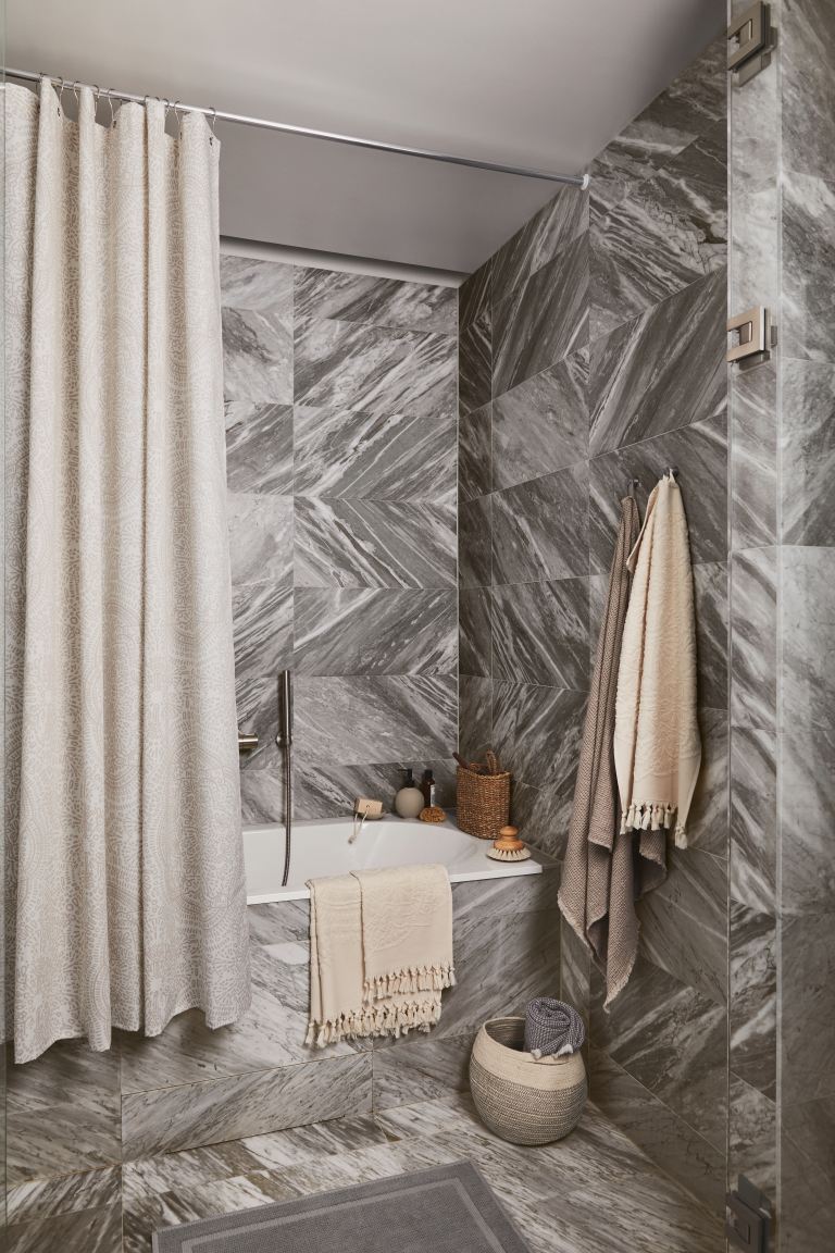 A bathroom idea including H&M Home bed and bathroom collection and grey marble effect wall tiles