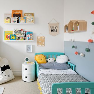 Nursery with white and grey walls, toddler's bed and book shelves
