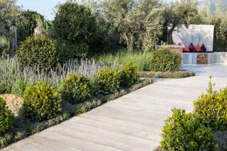 mediterranean garden ideas: white decked pathway lined with mediterranean plants