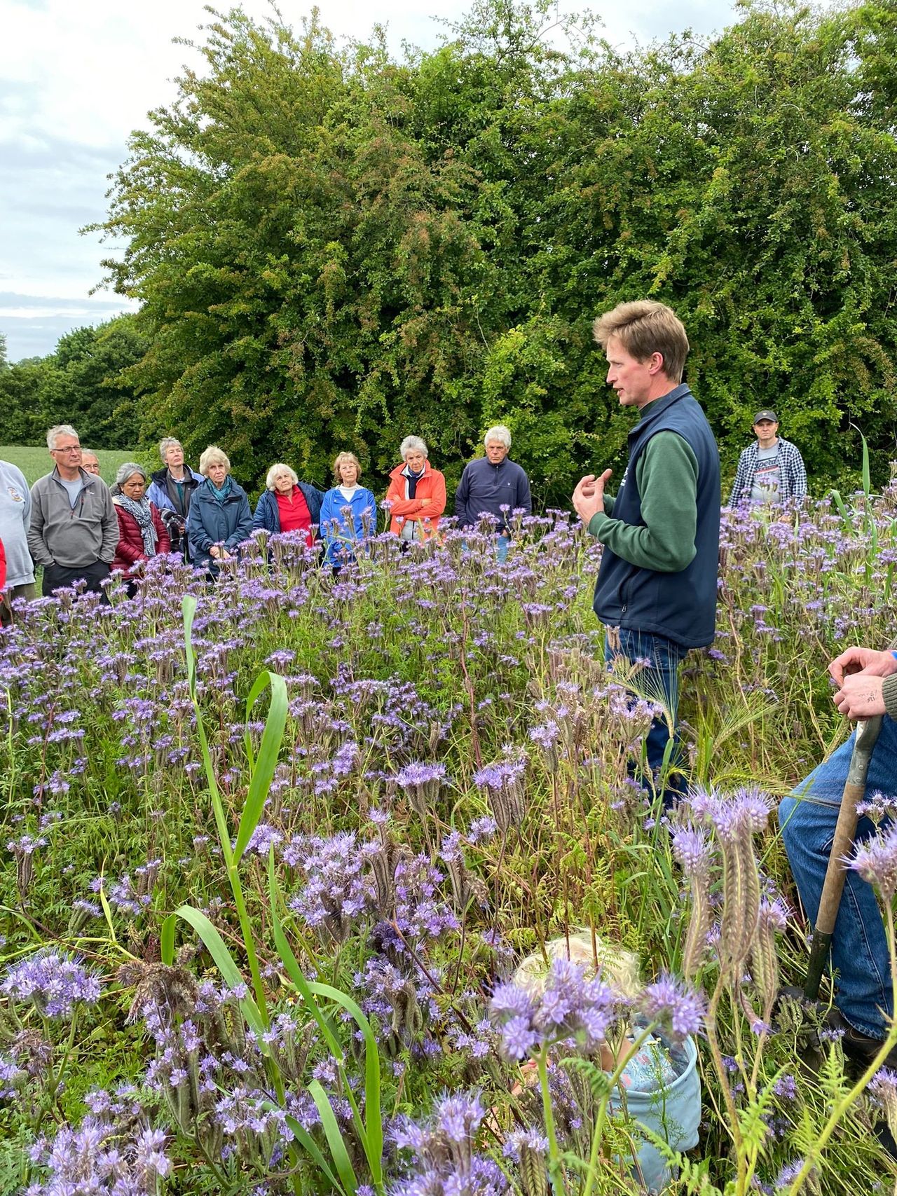 visitors listener to a farming talking in a filed