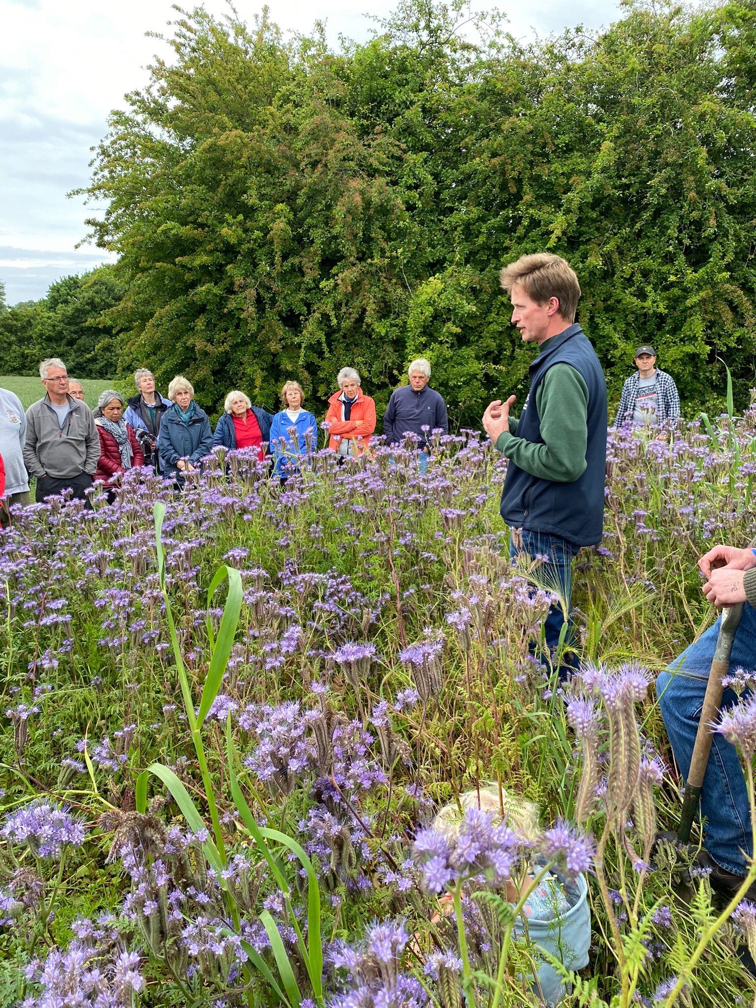 visitors listener to a farming talking in a filed