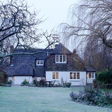 Rear exterior of a detached house with frosty garden and wintry trees