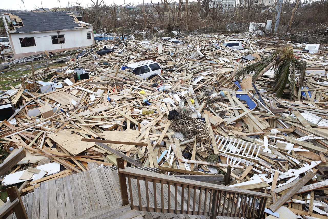 A car pokes out of a pile of rubble from houses