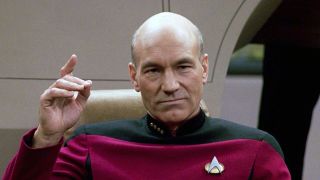 a bald man in a red starfleet uniform aboard the Starship enterprise