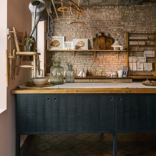 kitchen area with bricked wall and drawers