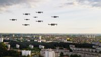 A drone swarm flying over a city