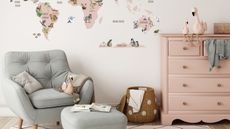 A pink nursery dresser with pink flamingo teddies on top. Next to a duck egg blue arm chair with a matching foot stool. A white wall behind wit the bottom of a cartoon world map decal visible. 