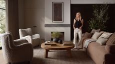 Amber Lewis in neutral living room with brown sofa, armchairs and rug 