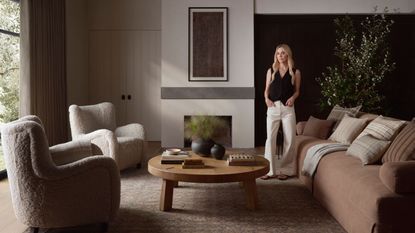 Amber Lewis in neutral living room with brown sofa, armchairs and rug