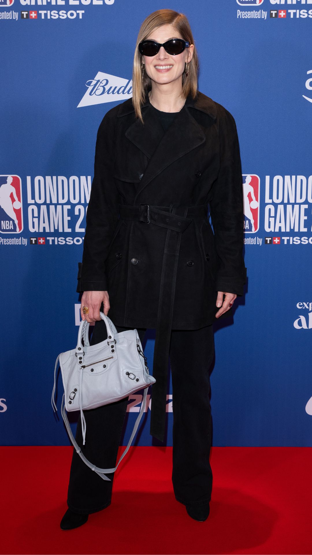 rosamund pike wearing all black with a white balenciaga bag