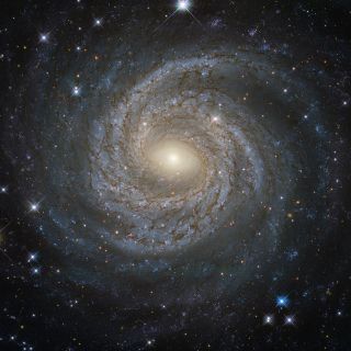 Galaxies such as this spiral, known as NGC 6814, are held together by mysterious dark matter.