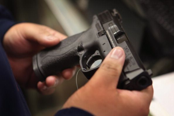 Man holds a gun at Freddie Bear Sports.