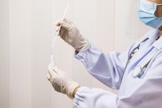 A doctor holding a SARS-CoV-2 test swab.