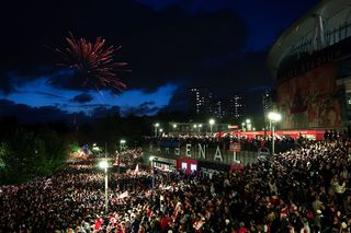 Fans celebrate as Arsenal are confirmed as Premier League champions, as they gather outside the Emirates Stadium, on May 19, 2026 in London, England.