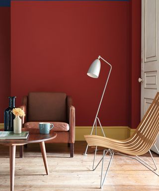 Abstract walls in a dark red living room by Little Greene