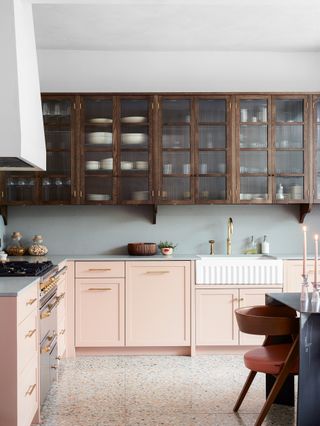 Pink and wood kitchen with glass fronted cabinets