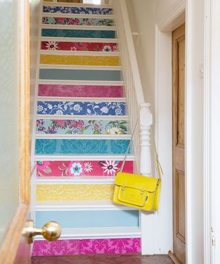 stair case with mutli coloured stair wallpaper and yellow handbag