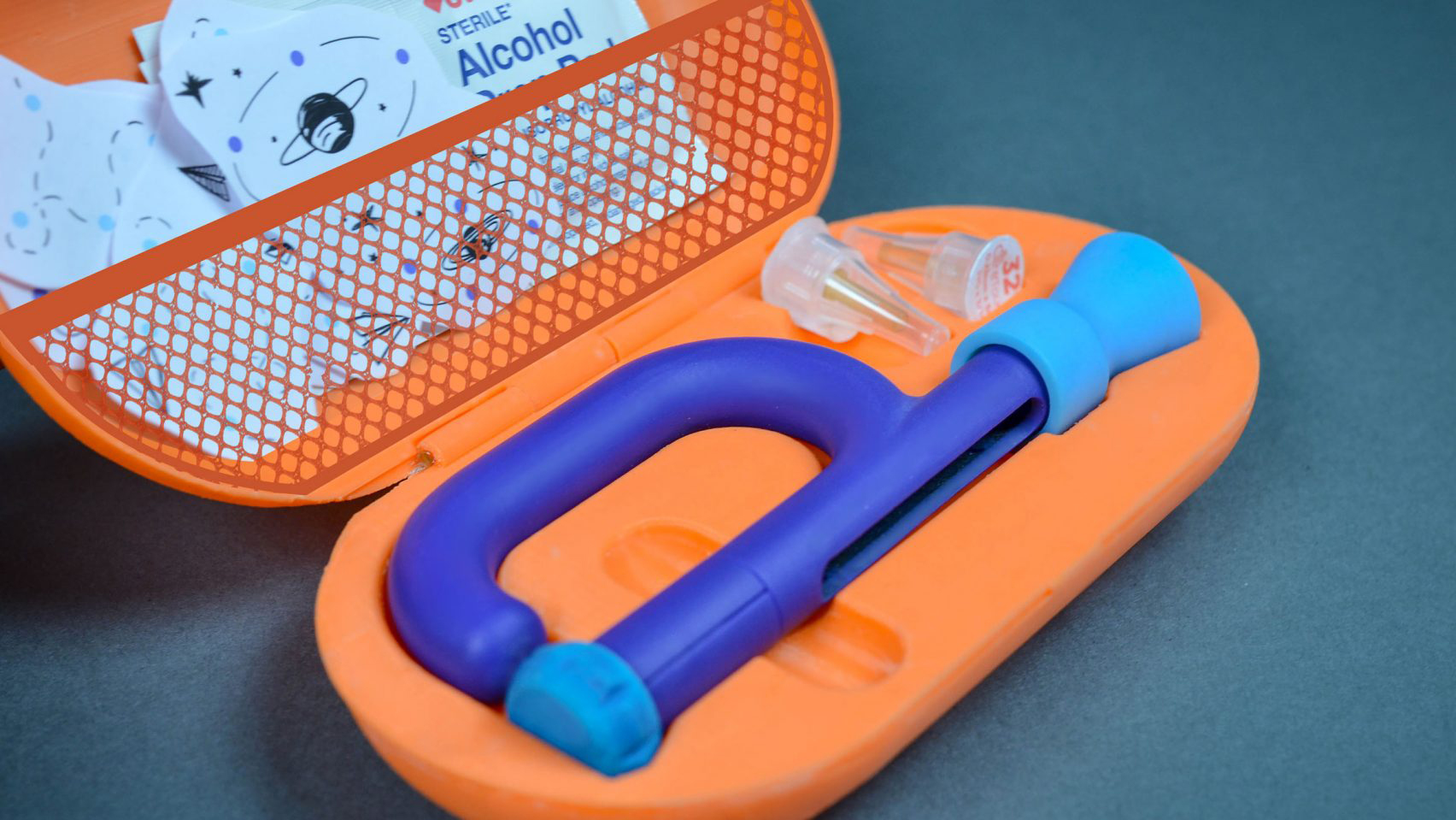 Colourful orange insulin kit containing an insulin pen and temporary tattoos for children
