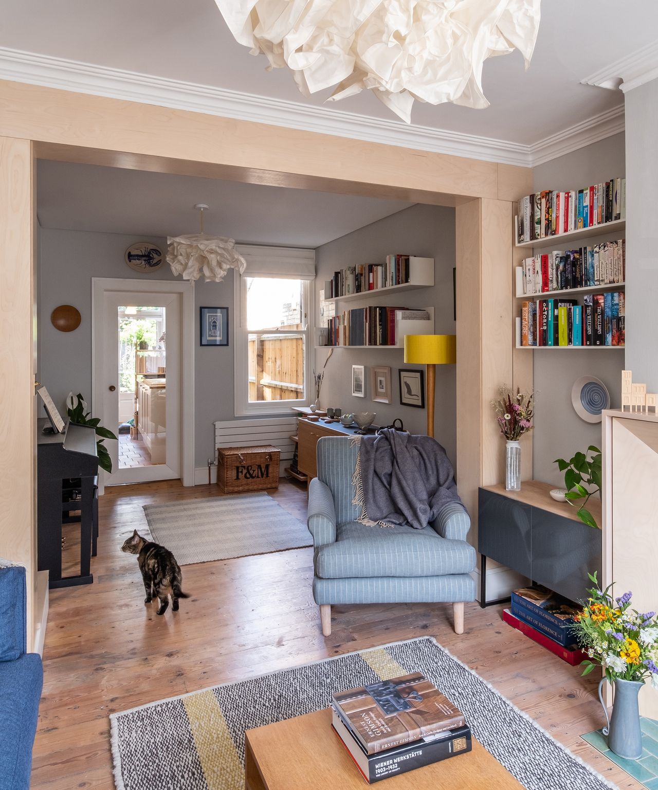 A large reception room in a Victorian house with wooden floorboards