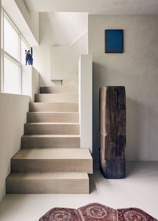 A large wooden block next to a minimalist staircase