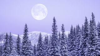 Moonrise in snowy mountains.