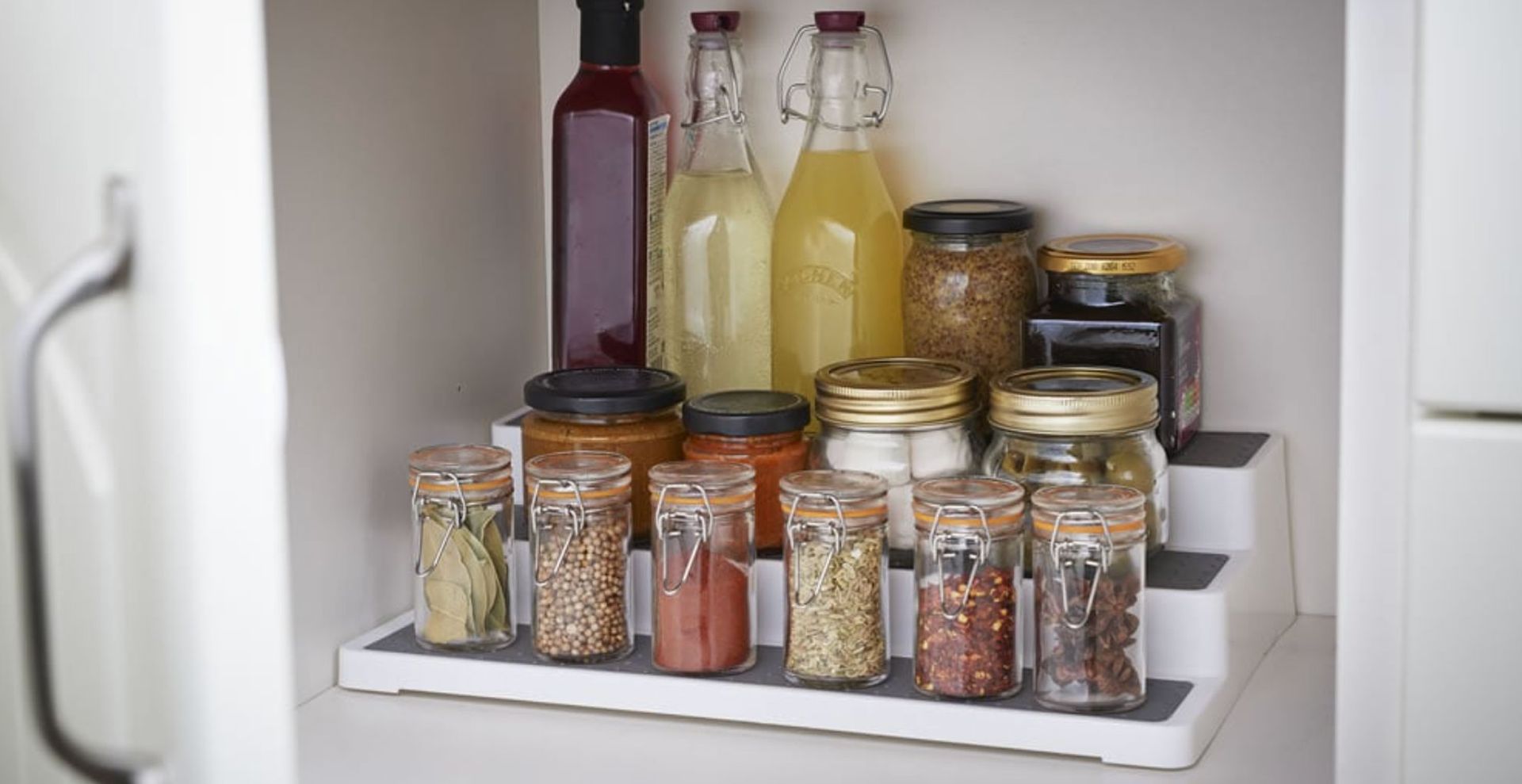 organize kitchen cabinet with staggered storage unit to store ingredients at different levels for ease