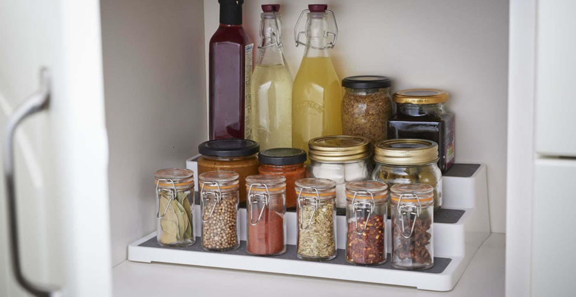 organize kitchen cabinet with staggered storage unit to store ingredients at different levels for ease