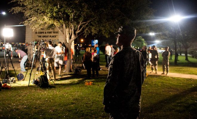 A soldier watches over media before a press conference about a shooting at Fort Hood Military Base in Texas.