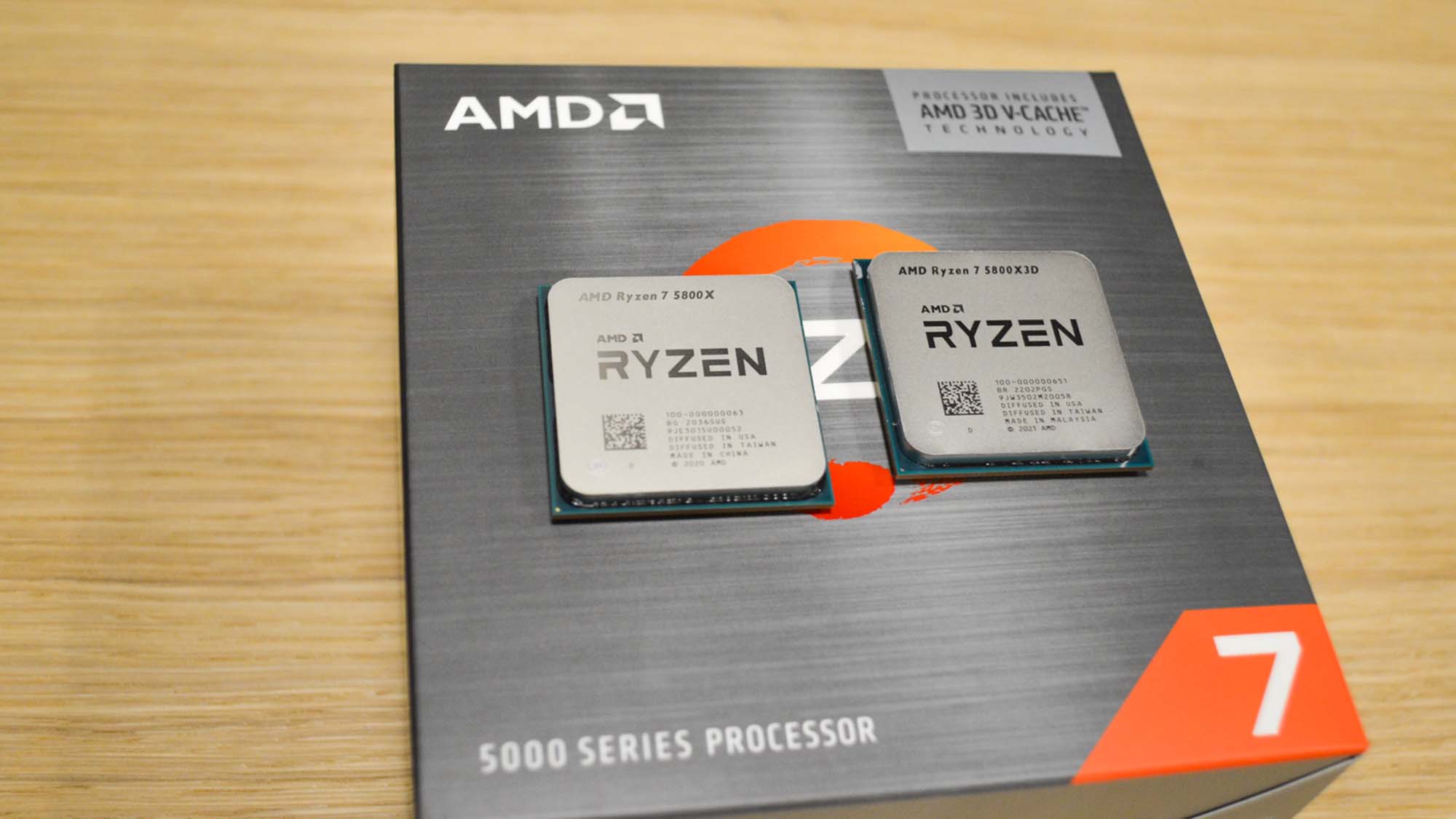 AMD Ryzen 7 5800X3D ja Ryzen 7 5800X vierekkäin myyntipaketin päällä