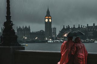 Two people standing in the rain by the Thames