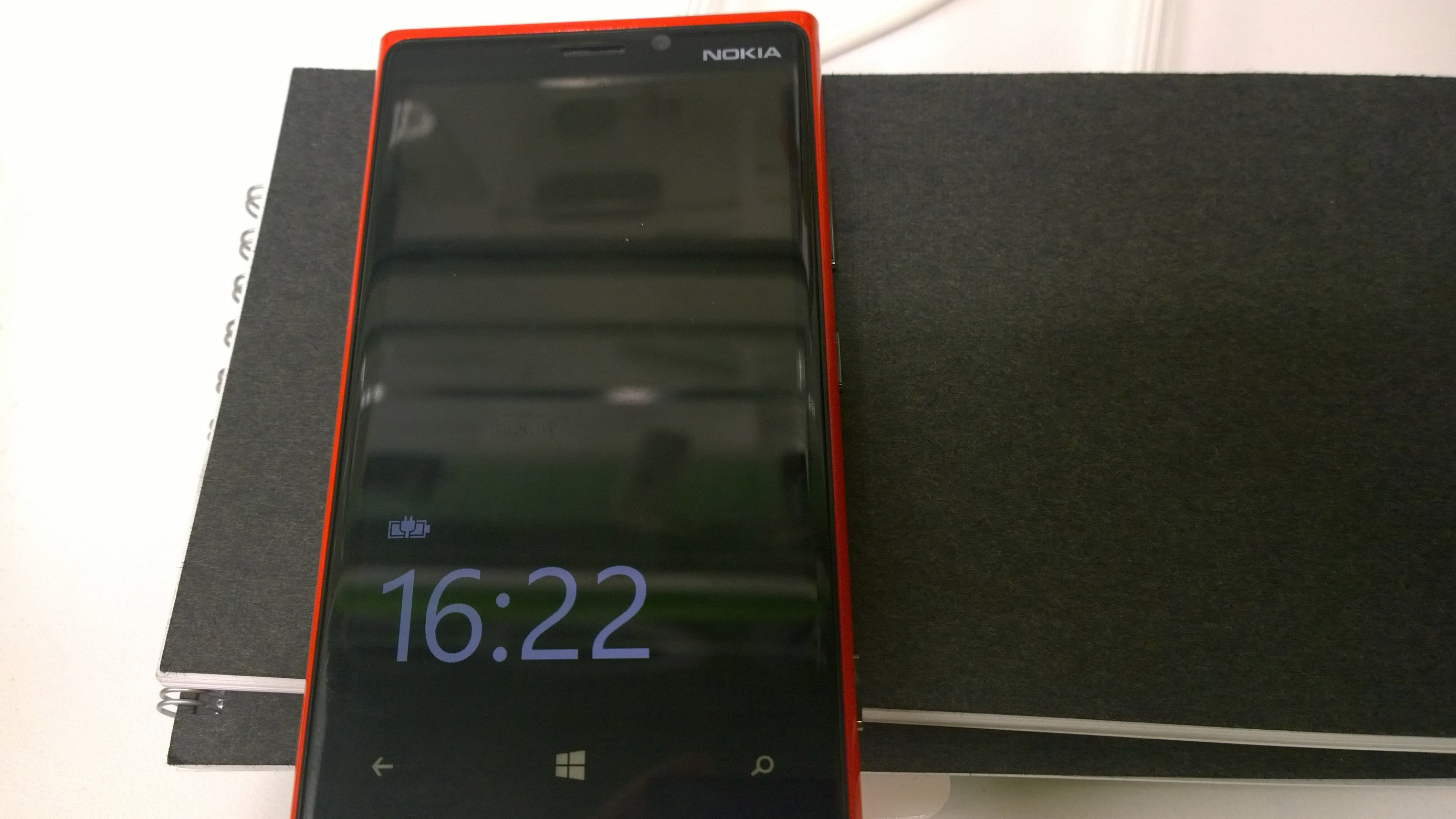 A resonant charging pad under two laptops delivers power to the phone
