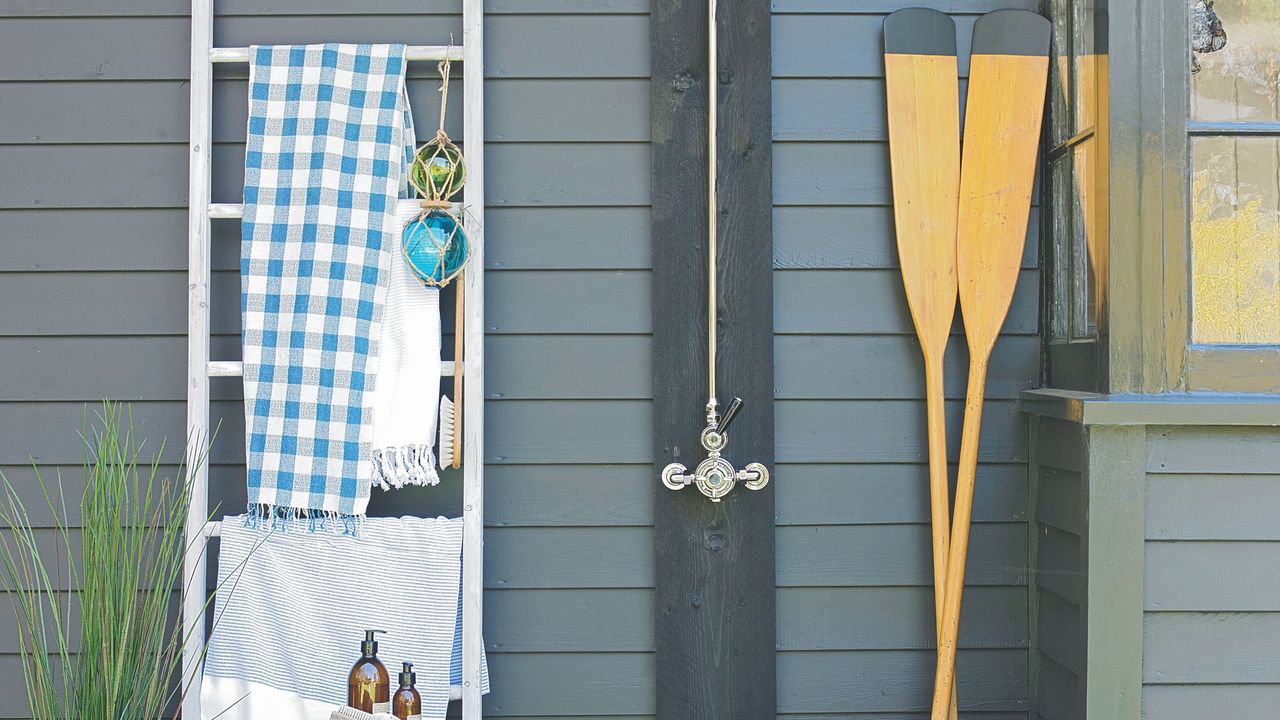 Towels hanging on rack in garden next to wooden oars