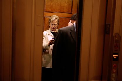 Hillary Clinton checks her BlackBerry